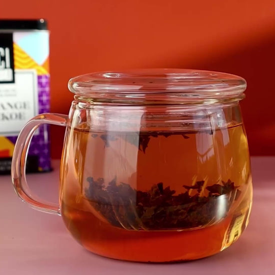 Orange Pekoe tea brewing in a glass infuser tea cup.